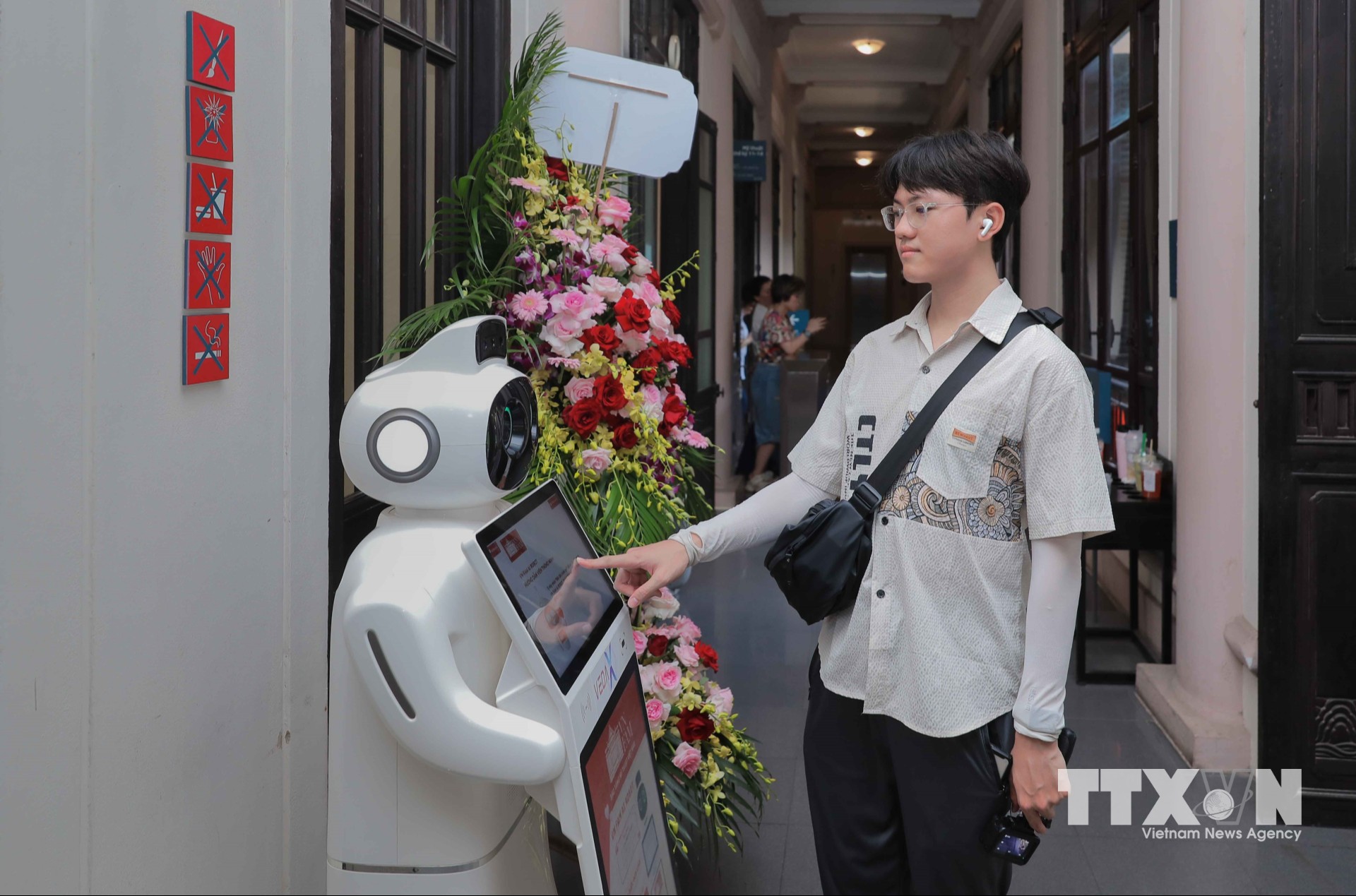 Khách tham quan tại Bảo tàng Mỹ thuật Việt Nam có thể trực tiếp tương tác với robot AI thông minh để tra cứu thông tin, nghe giới thiệu hiện vật và nhận hướng dẫn lộ trình tham quan chi tiết bằng nhiều thứ tiếng. (Ảnh: Phan Phương/TTXVN)